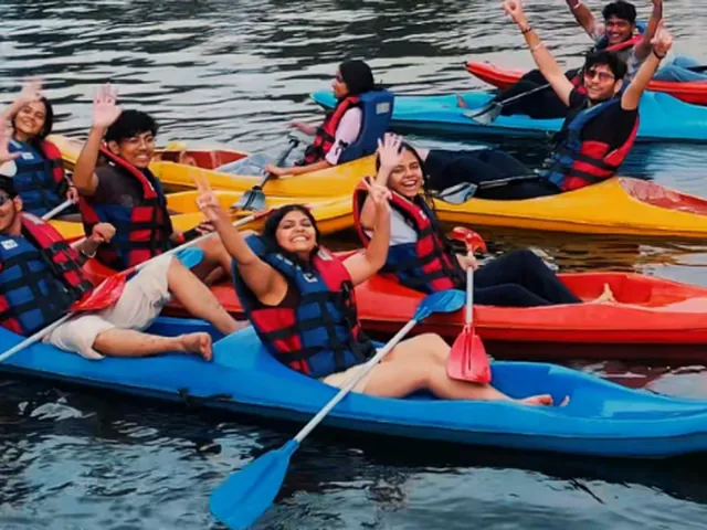 Guests waving from their kayaks on the backwaters